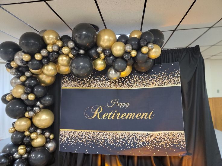 a black and gold retirement sign surrounded by balloons