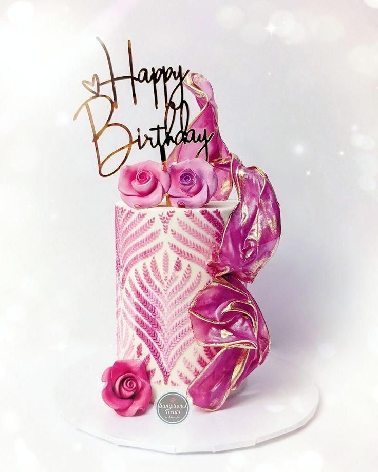 a birthday cake decorated with pink roses and gold foil