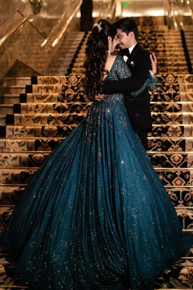 a man and woman dressed in formal wear kissing on the steps of an escalator