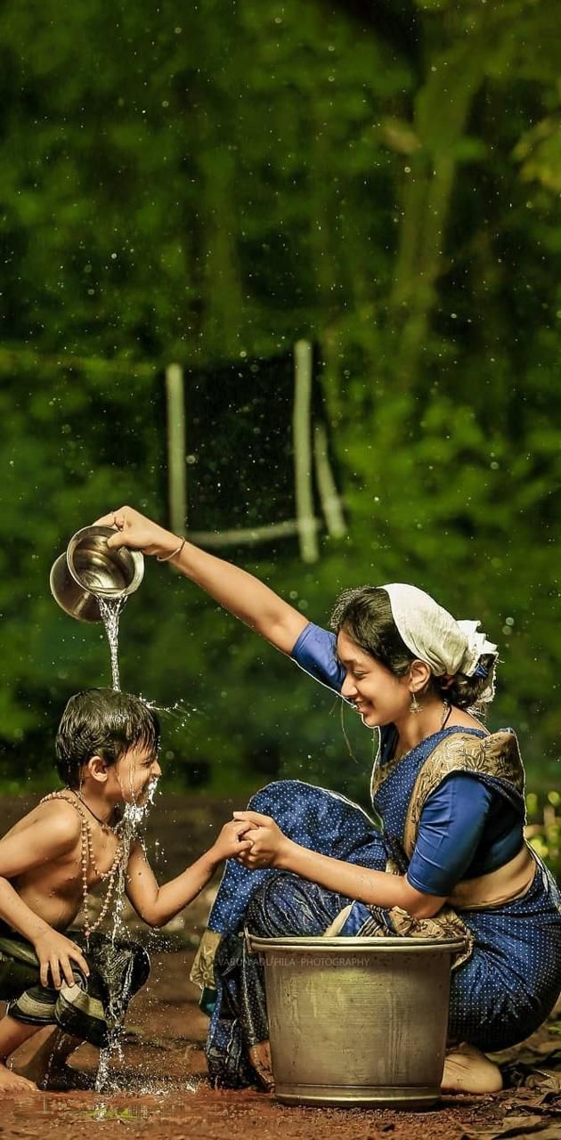 two children are playing with water in a bucket