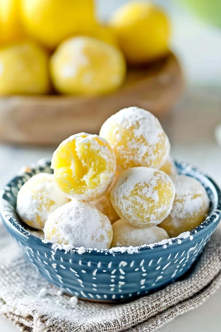 powdered sugar coated lemons in a blue bowl