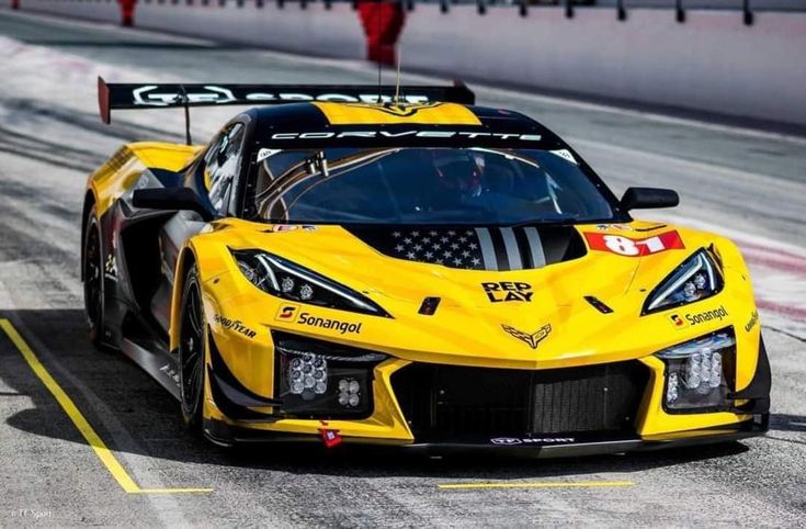 a yellow sports car driving down a race track