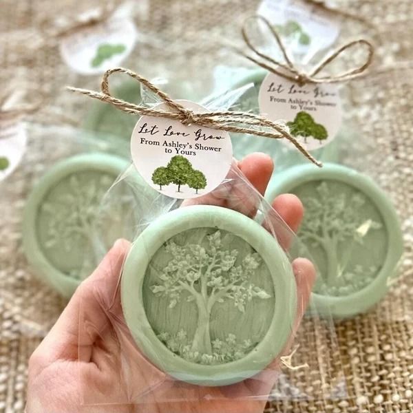 someone is holding some soaps in their hands and they have trees printed on them