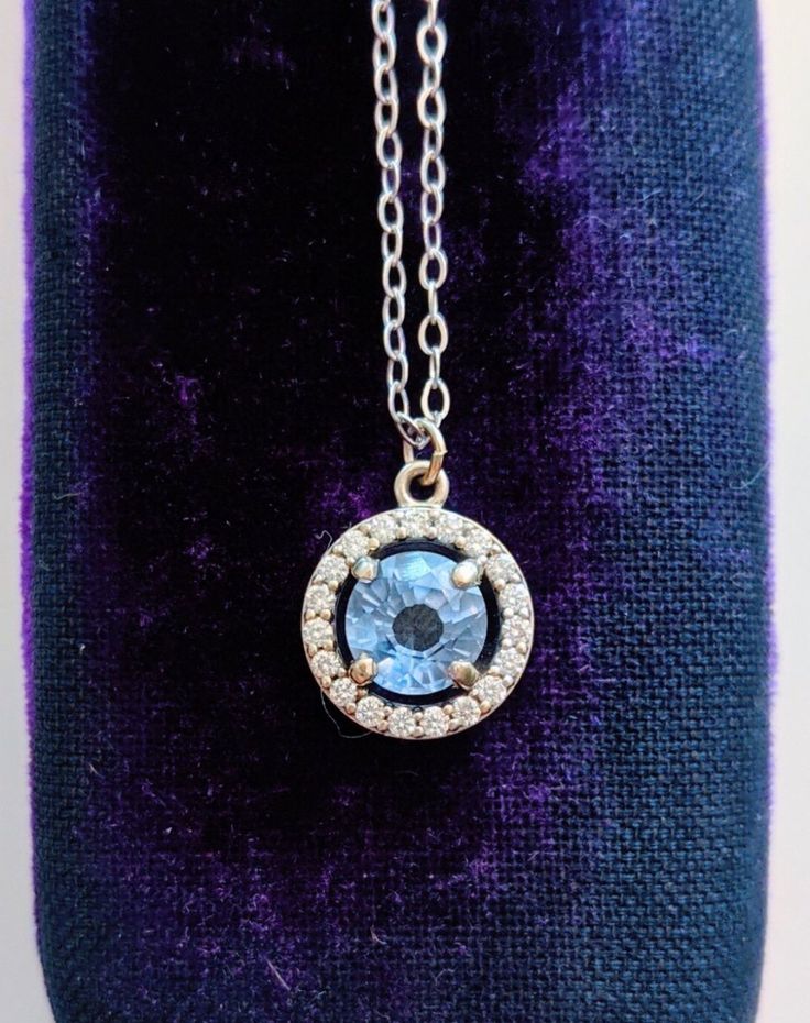 A gorgeous blue sapphire sparkles in the light, accented by a circle of diamonds. Set in 14k white gold, this is the prettiest sapphire necklace you may ever see! Handcrafted in 14k white gold Features a sapphire surrounded by a diamond halo Sapphire measures approx. 5.5mm in diameter Pendant measures approx. 10mm in diameter Full necklace hangs at 18" with a 14k lobster clasp Formal Blue Necklace With Halo Setting, Formal Blue Necklaces With Halo Setting, Dazzling Blue Necklace With Brilliant Cut, Sapphire Jewelry With Brilliant Cut Round Stone, Gift Jewelry With Center Stone In Round Pendant, Round Pendant Jewelry With Center Stone For Gift, Sapphire Necklaces With Halo Setting, Formal Blue Topaz Jewelry With Halo Setting, Round Lab-created Sapphire Birthstone Jewelry