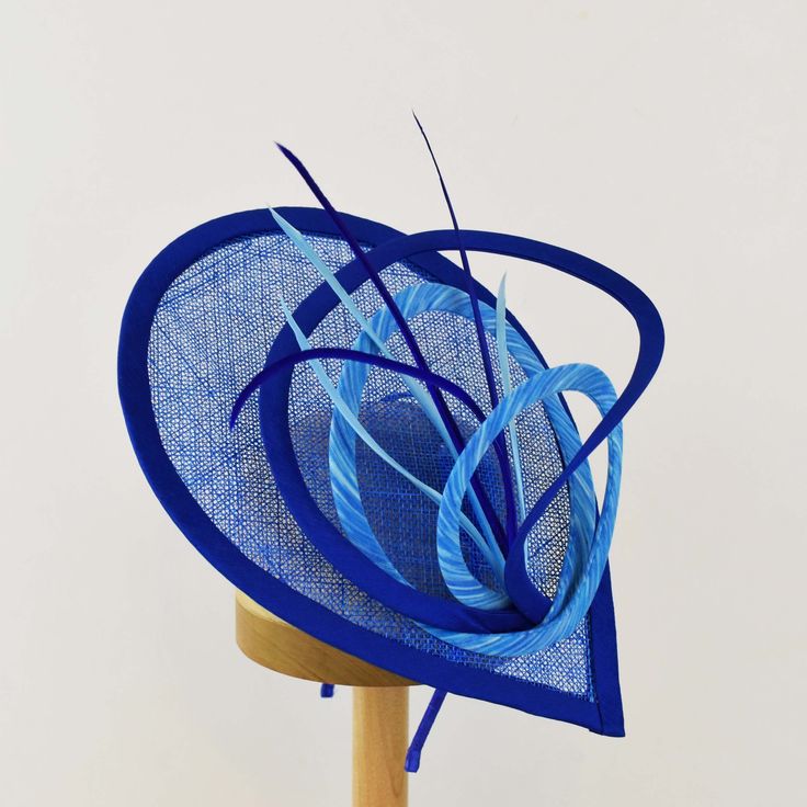 "Spring up your party outfit another notch with a fascinator made for a celebration or a day at the races.  The teardrop shaped sinamay base provides the backdrop as the colored fabric loops swirl to create height and dimension.  Biot feathers in a variety of complementary colors provide the finishing touch.   - Light Weight - Approximately 9\" X 12\" - Attaches with a headband. - Choices of many colors for base and loops.   - Each piece is unique and will vary slightly. Please note that color in photos may be different than actual color.  I am always happy to send color samples. If you have any special requests or questions please don't hesitate to contact me. Need a different color?  Message me and I will do my best to meet your needs. This is a made to order item with production startin Fascinator Hats Diy, Rabbit Fur Hat, Blue Fascinator, Hat Art, Day At The Races, Senior Project, Head Dress, Feather Hat, Fascinator Hat