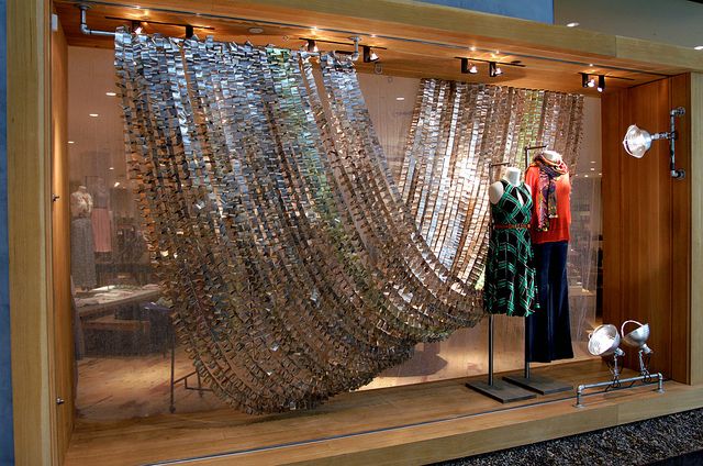 two mannequins are standing in front of a display window with glass beads