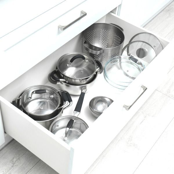 an open drawer with pots and pans in it