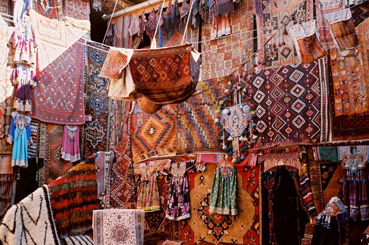 an alley way with lots of baskets and paintings on the walls, along with other items