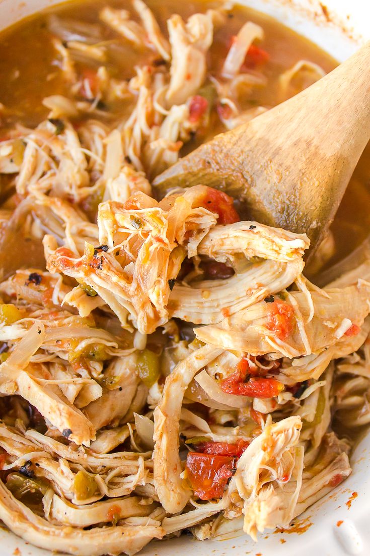 a wooden spoon in a bowl filled with chicken tortilla soup