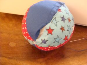 a blue and red ball sitting on top of a wooden floor