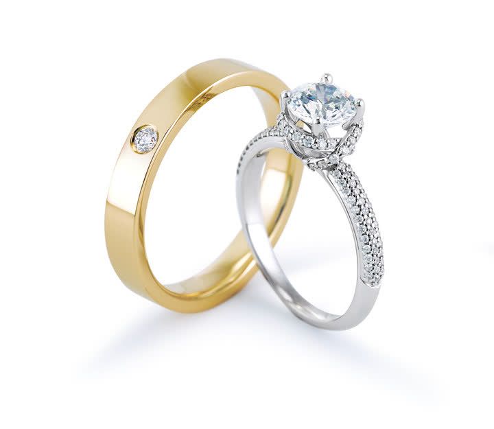 two gold and silver wedding rings with diamonds on the sides, one has a diamond set in