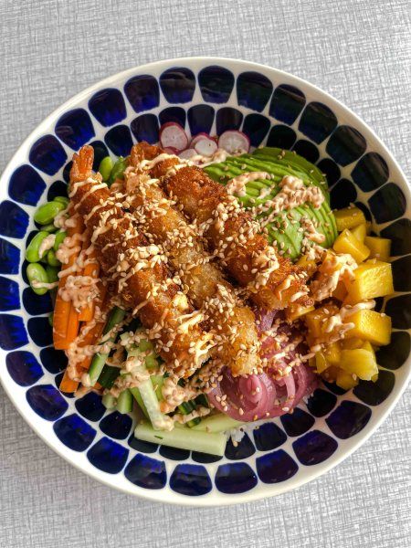 a blue and white bowl filled with food on top of a table