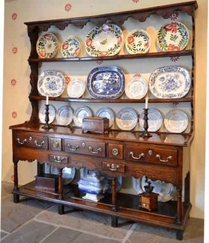 an old china cabinet with plates on it