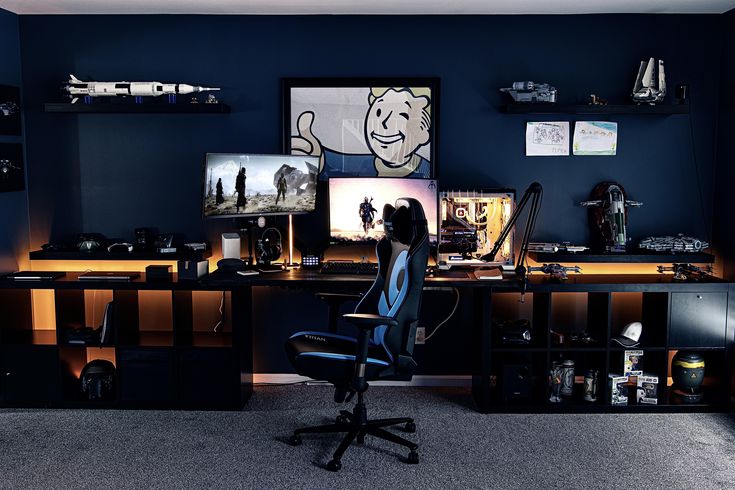 a person sitting at a desk in front of two computer monitors and a monitor screen