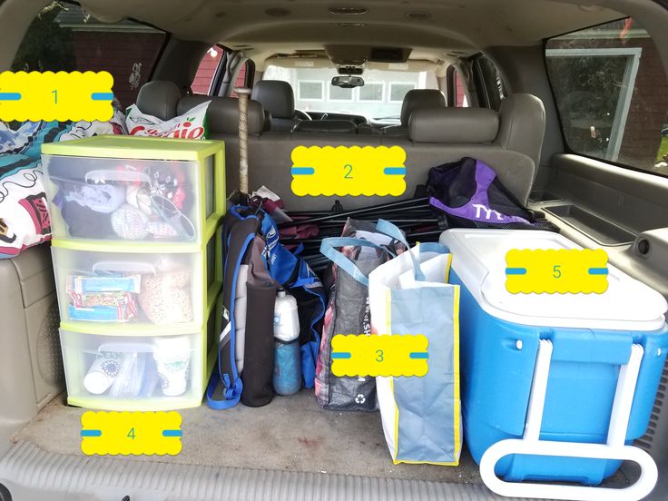 the back end of a van filled with various items and storage bins for cars