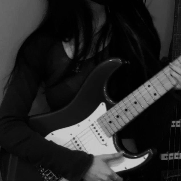 a woman is playing an electric guitar in black and white