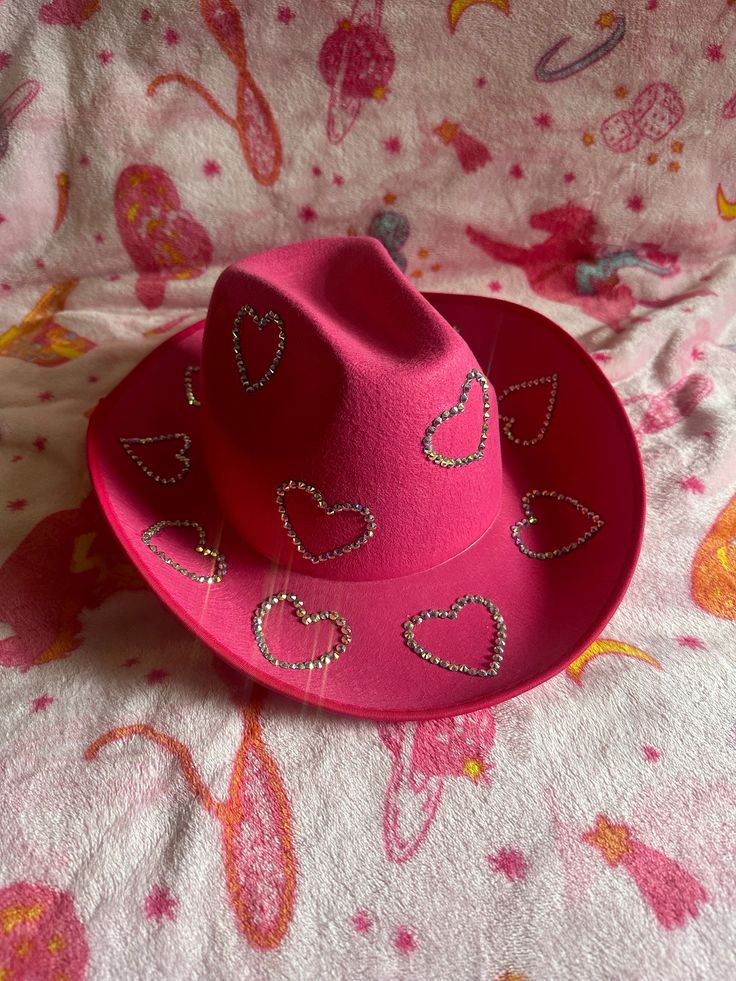 Rhinstone heart cowgirl hat. You can get it in pink, white, or black. This is the perfect hat for a special event (birthday or bachelorette) or for when your feeling just a little extra on a night out! Every Rhinstone is hand placed. This is a made to order item. Cowgirl Hats Bachelorette, Decorated Cowgirl Hats Party, Diy Bedazzled Cowboy Hat, Hot Pink Cowgirl Outfit, Cowgirl Hat Ideas, Diy Cowgirl Hat Ideas Pink, Chappell Roan Party, Pink Cowgirl Hat, Diy Cowboy Hat Decoration