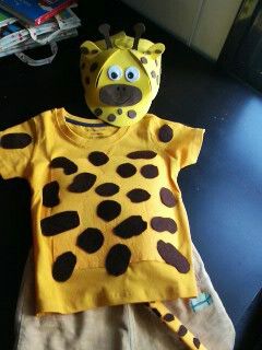 a stuffed giraffe wearing a yellow shirt and tan pants