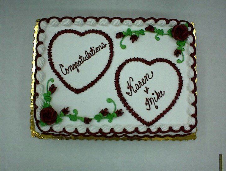 two hearts shaped cake with congratulations written on them and roses in the middle, sitting on a table