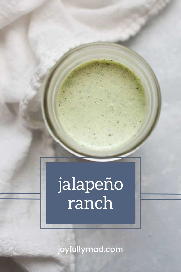 a jar filled with green liquid sitting on top of a white cloth