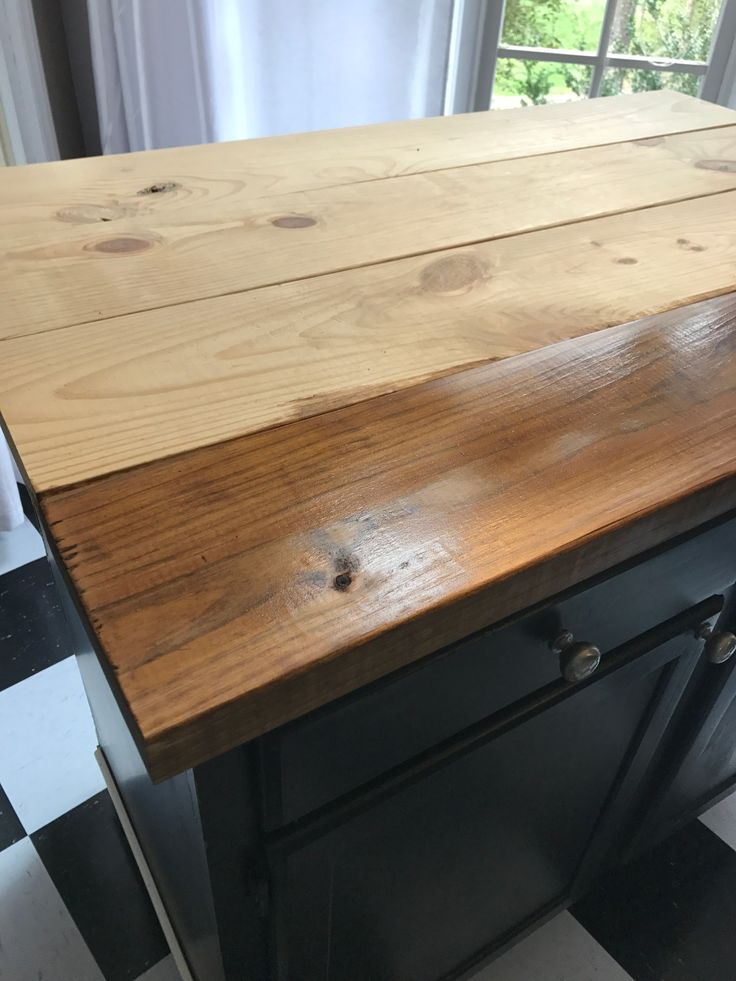 a wooden counter top sitting on top of a black and white checkered floor