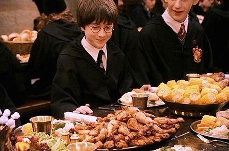 some harry potters are sitting at a table full of food