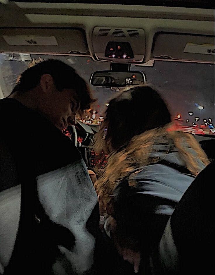 two people sitting in the back seat of a car