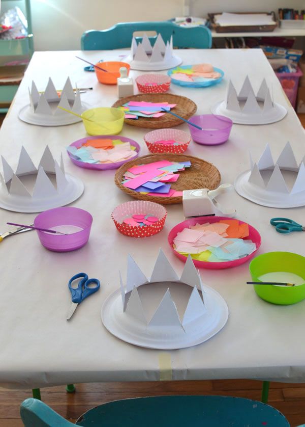 a table with paper plates and cupcakes sitting on it's sides, all decorated in crowns