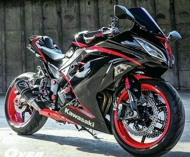 a red and black motorcycle parked in front of a building