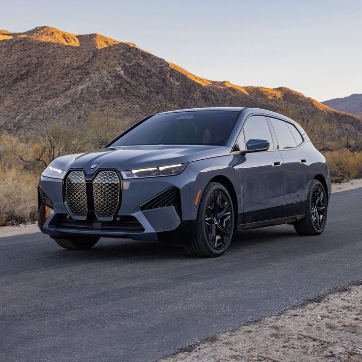 the all - new bmw x7 suv is shown in front of mountains and desert