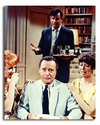 three people sitting at a table in front of a man holding a plate with food on it