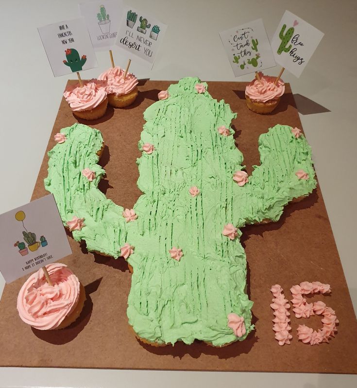 a cake made to look like a cactus with cupcakes on the table next to it