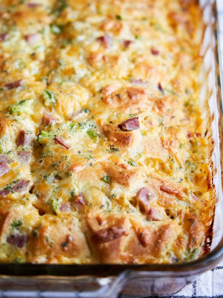 a casserole dish with ham, cheese and broccoli in it on a table