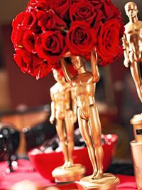 there is a gold statue with red roses in front of it and an award on the table