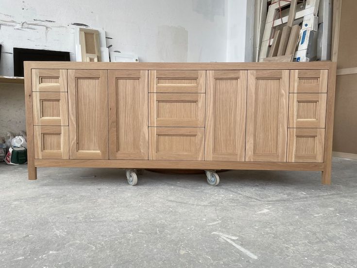 a large wooden cabinet sitting on wheels in a room