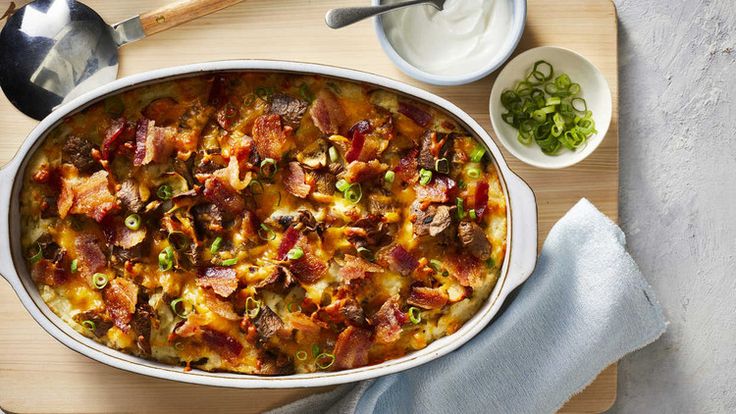 a casserole dish with meat and vegetables on a cutting board next to other dishes