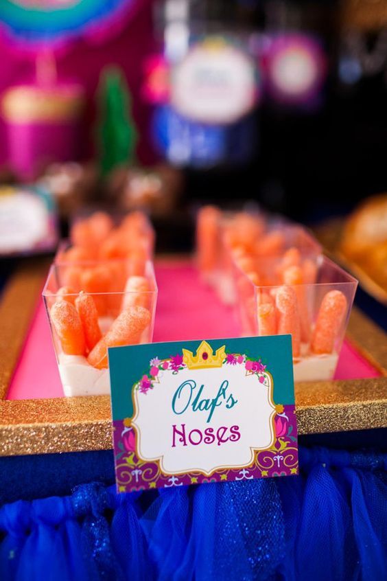 there are many small cups with candy in them on the table at this birthday party