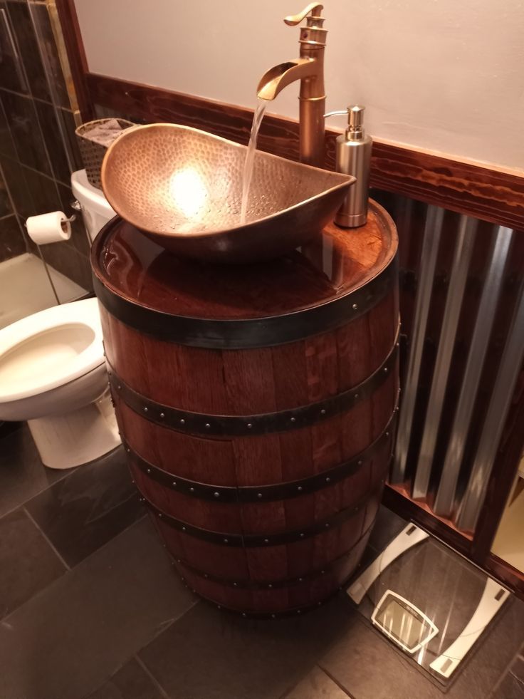 a sink that is sitting on top of a wooden barrel in a bathroom with tile flooring