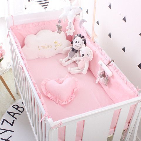 a pink baby crib with stuffed animals in it