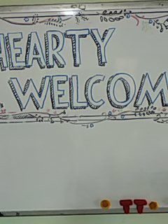 a white board with the words hearty welcome written on it