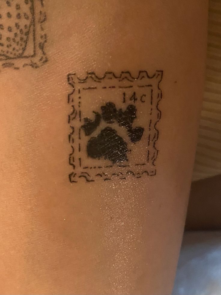 a tattoo on the back of a woman's leg with a dog paw stamp