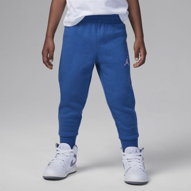 A simple yet comfy design made of fleece knit fabric with a soft brushed finish, these tapered pants have rib knit cuffs for a cozy feel. Pockets on the sides and back provide spots to stash small items and the elasticized waistband with drawcord helps kiddos get a fit that's just right so they can play hard or relax well. Pair with any of the Jordan MJ Essentials tops for a coordinated look. Blue Cotton Sweatpants With Ribbed Cuffs, Blue Cotton Pants With Ribbed Cuffs, Blue Fleece Joggers With Elastic Waistband, Blue Fleece Sweatpants With Elastic Waistband, Blue Athleisure Pants With Ribbed Cuffs, Blue Sportswear Bottoms With Ribbed Cuffs, Blue Winter Sweatpants With Ribbed Cuffs, Blue Bottoms With Ribbed Cuffs For Winter, Blue Winter Bottoms With Ribbed Cuffs