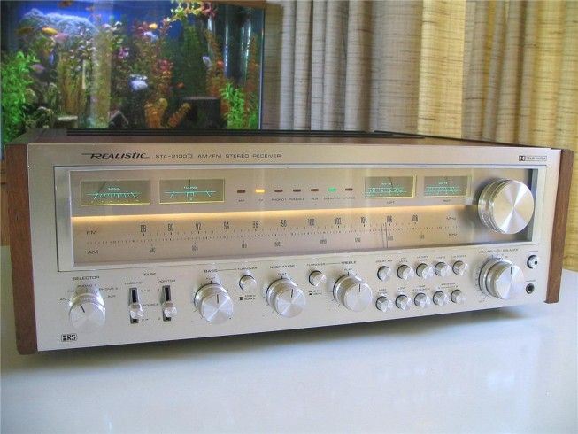 an old radio sitting on top of a table next to a fish tank in the background