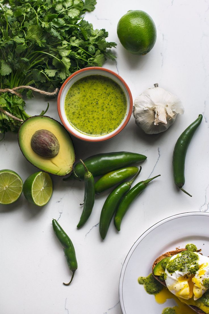 an assortment of food on a table including eggs, avocado and limes