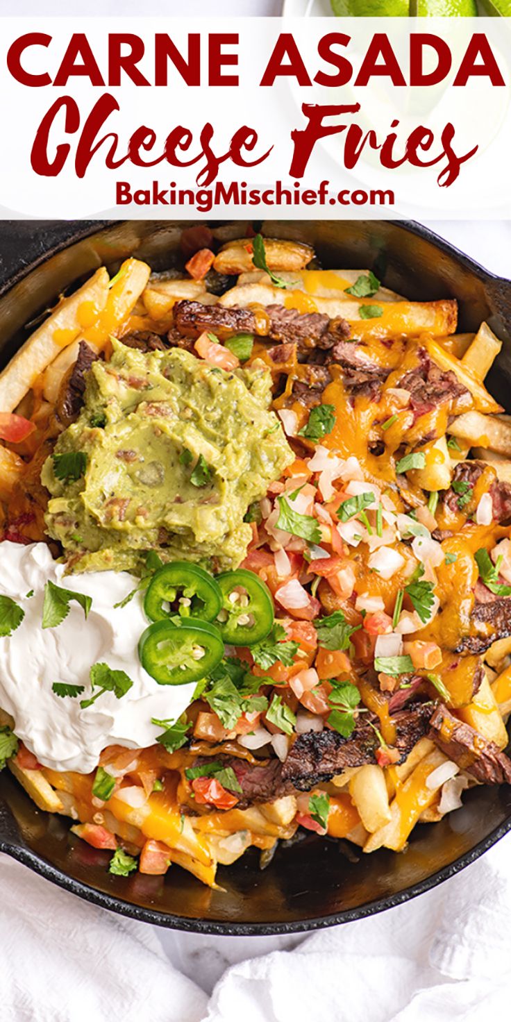 a skillet filled with cheese fries, guacamole and sour cream on top