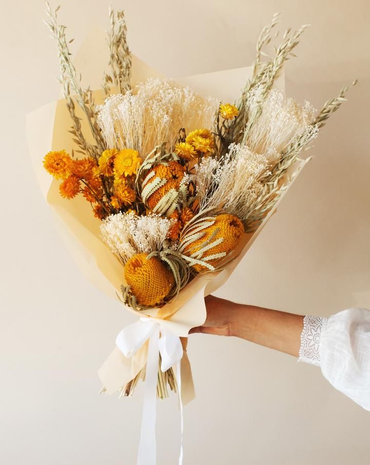 a person holding a bouquet of flowers in their hand