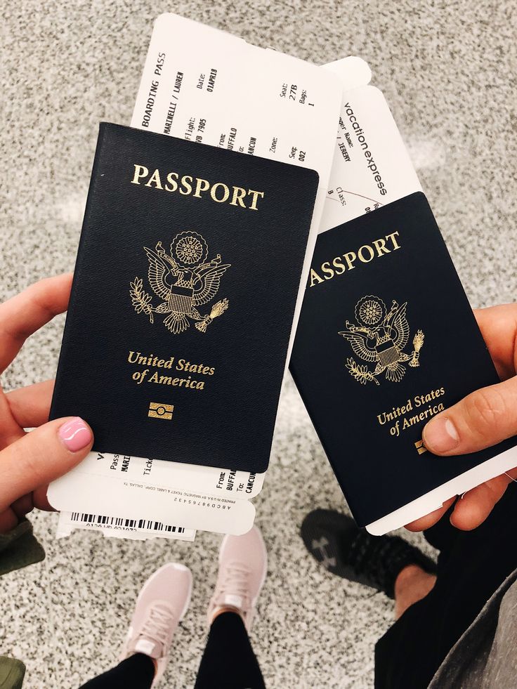 two people holding up their passport cards