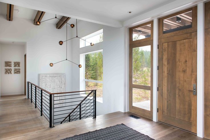 an empty room with wooden doors and metal railings on the second floor, leading to a balcony