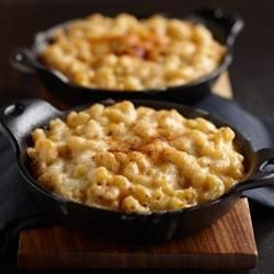 macaroni and cheese casserole in a black pan on a wooden table