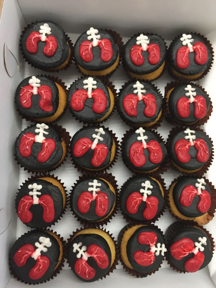 a box filled with cupcakes covered in red and black frosting